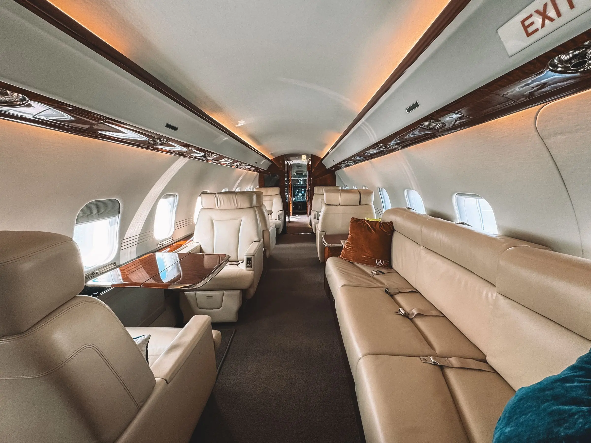 Cream leather seats and wood trim inside a private jet cabin